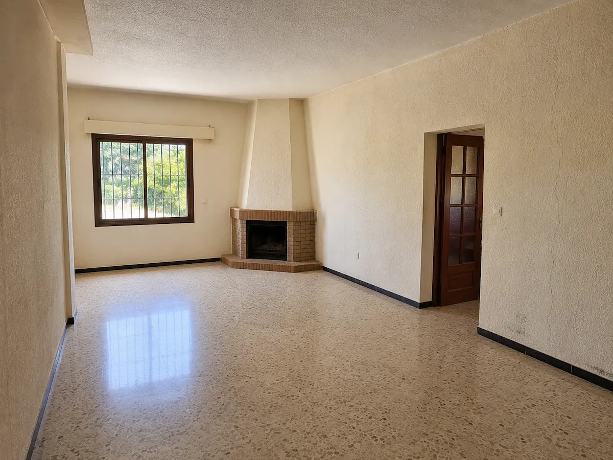 Salón y comedor vacío de un chalet con paredes de gotelé antes de alisar y pintar.
