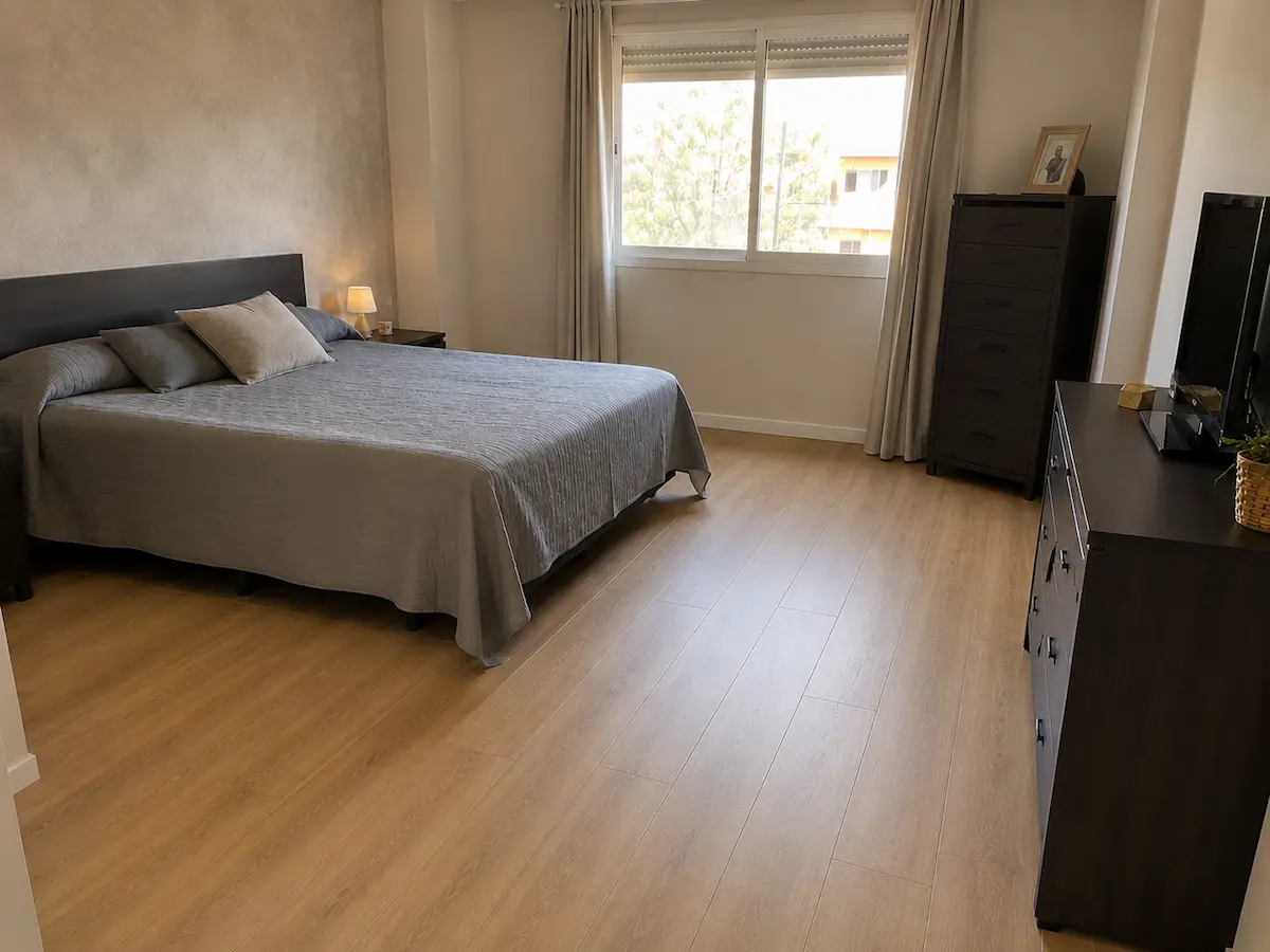 Dormitorio renovado con suelo PVC click efecto madera y pared de pintura decorativa en acabado mineral.