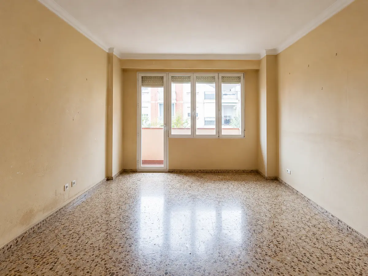 Piso vacío en Benimaclet antes de pintar, con paredes desgastadas, roces y pequeños desperfectos.