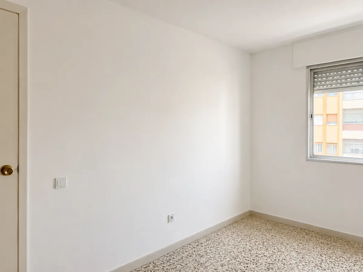 Dormitorio con paredes lisas después de eliminar el gotelé en Valencia